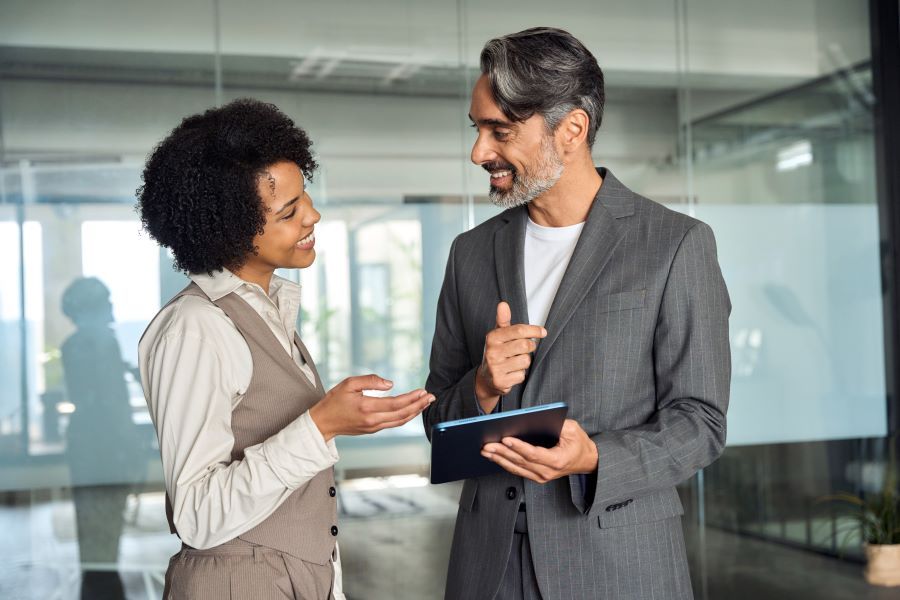 Dekoratives Bild: Zwei Personen sprechen in einem Büro. 