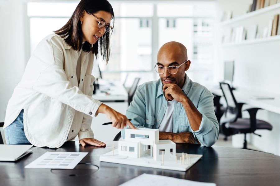 Dekoratives Bild: zwei Personen mit Architekturmodell