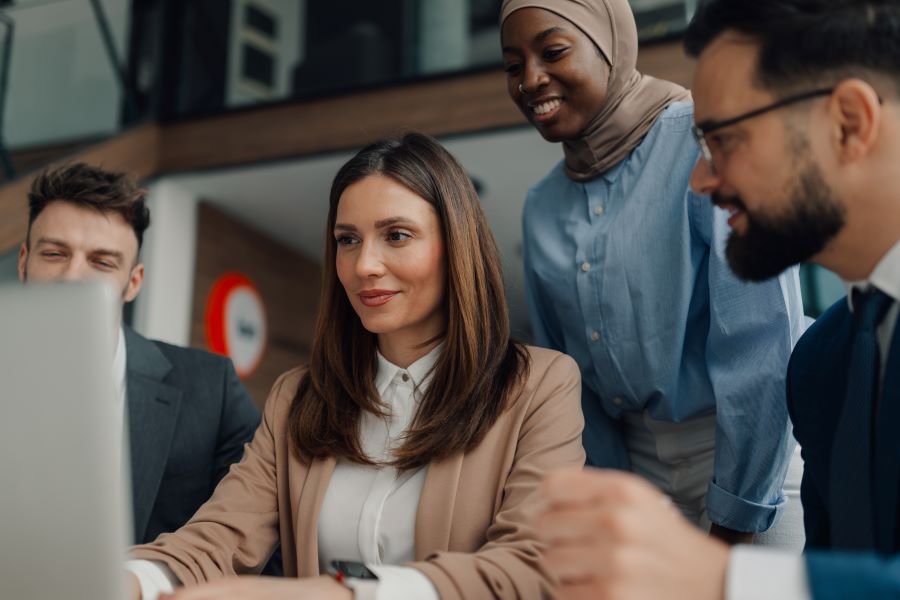 Dekoratives Bild: diverses Team um Laptop