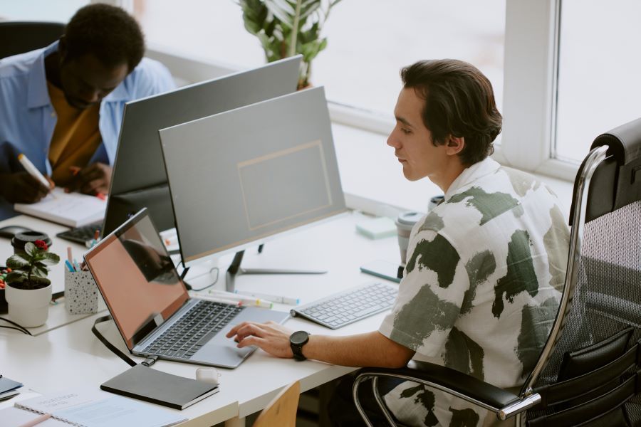 Dekoratives Bild: Mann mit Laptop und Bildschirm