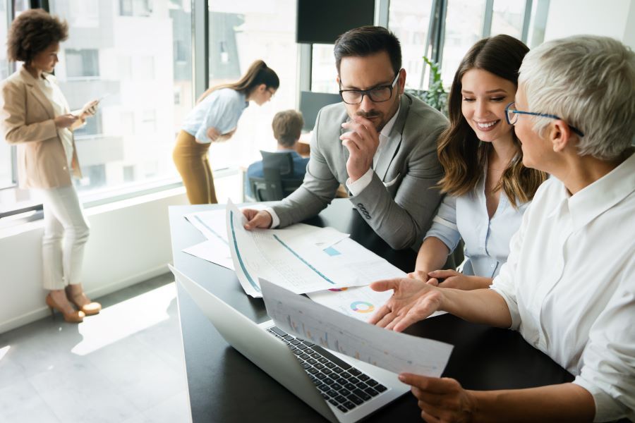 Dekoratives Bild: Team mit Statistiken und Laptop