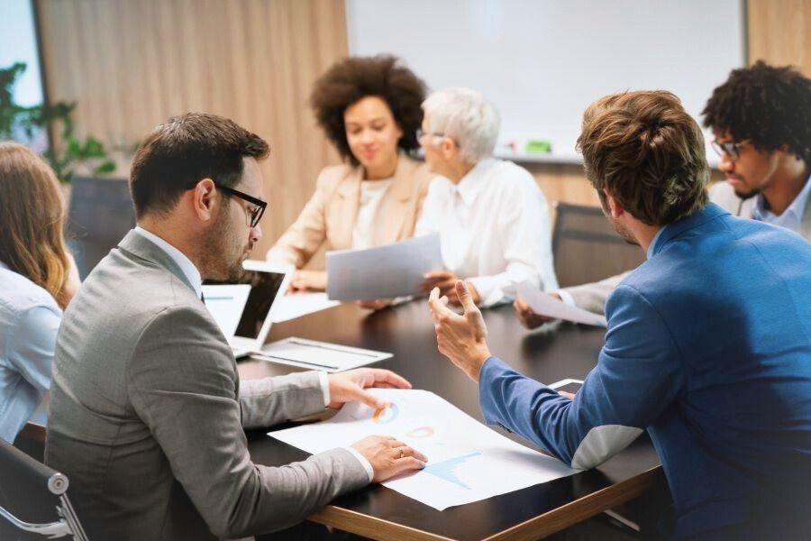 Dekoratives Bild: Team in Konferenz mit Statistiken