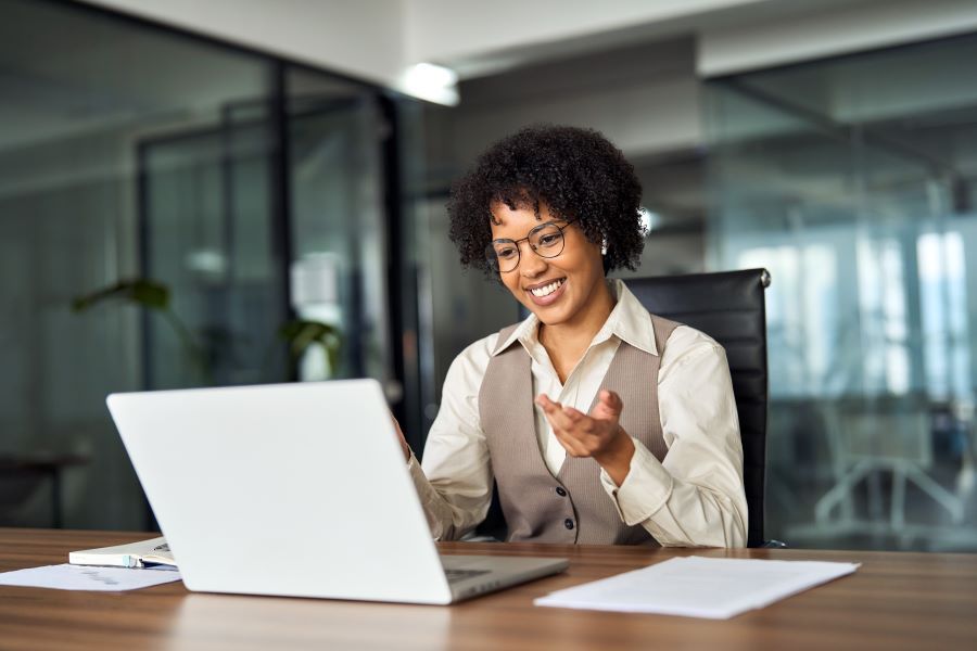 Dekoratives Bild: Frau mit In-Ear-Kopfhörern vor Laptop