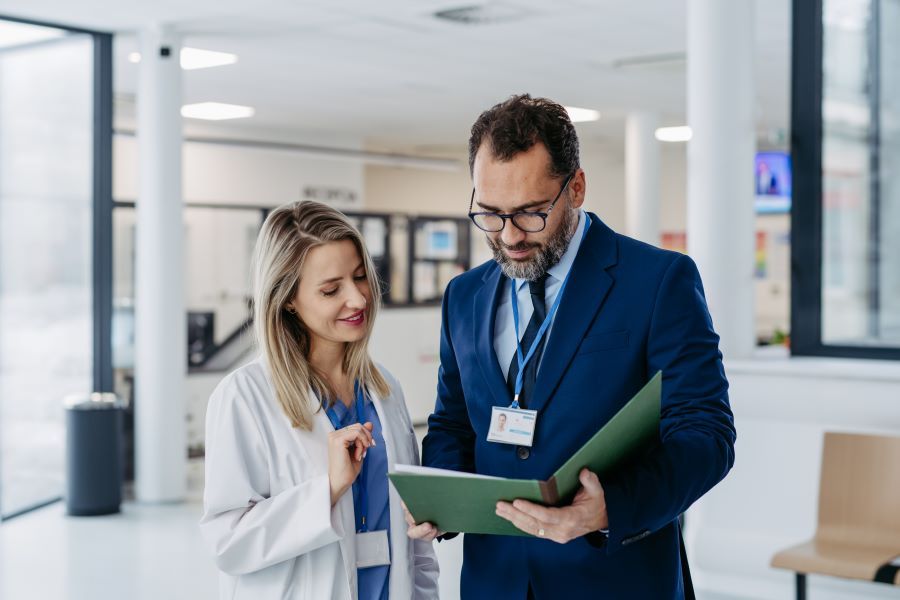 Dekoratives Bild: zwei Personen in Klinik mit Ordner