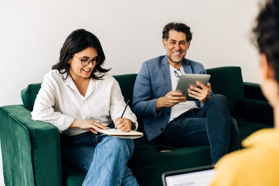 Dekoratives Bild: zwei Personen auf Sofa am Notizen machen