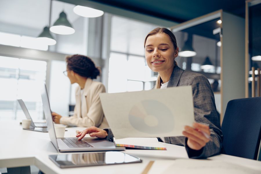 Dekoratives Bild: 2 Frauen am Schreibtisch mit Laptops und Unterlagen