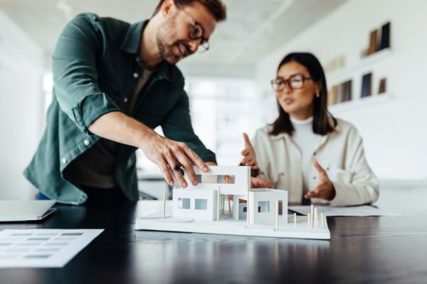 Dekoratives Bild: zwei Personen mit Architekturmodell