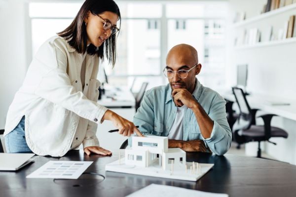 Dekoratives Bild: zwei Personen mit Architekturmodell
