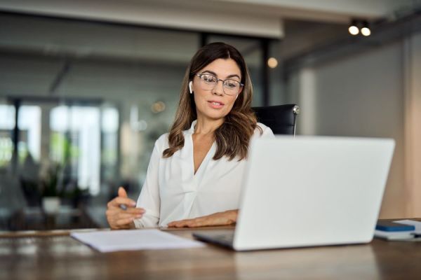 Dekoratives Bild: Frau mit In-Ear-Kopfhörern am Laptop