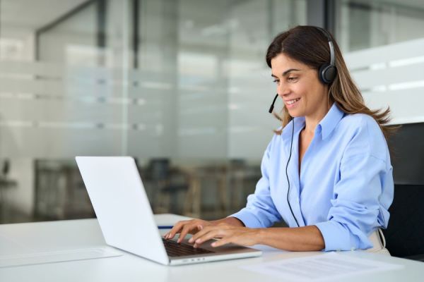 Dekoratives Bild: Frau mit Headset am Laptop