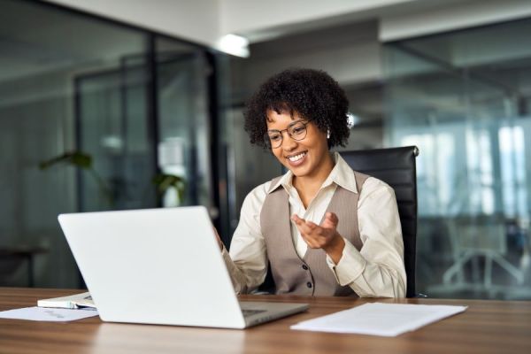 Dekoratives Bild: Frau mit In-Ear-Kopfhörern vor Laptop